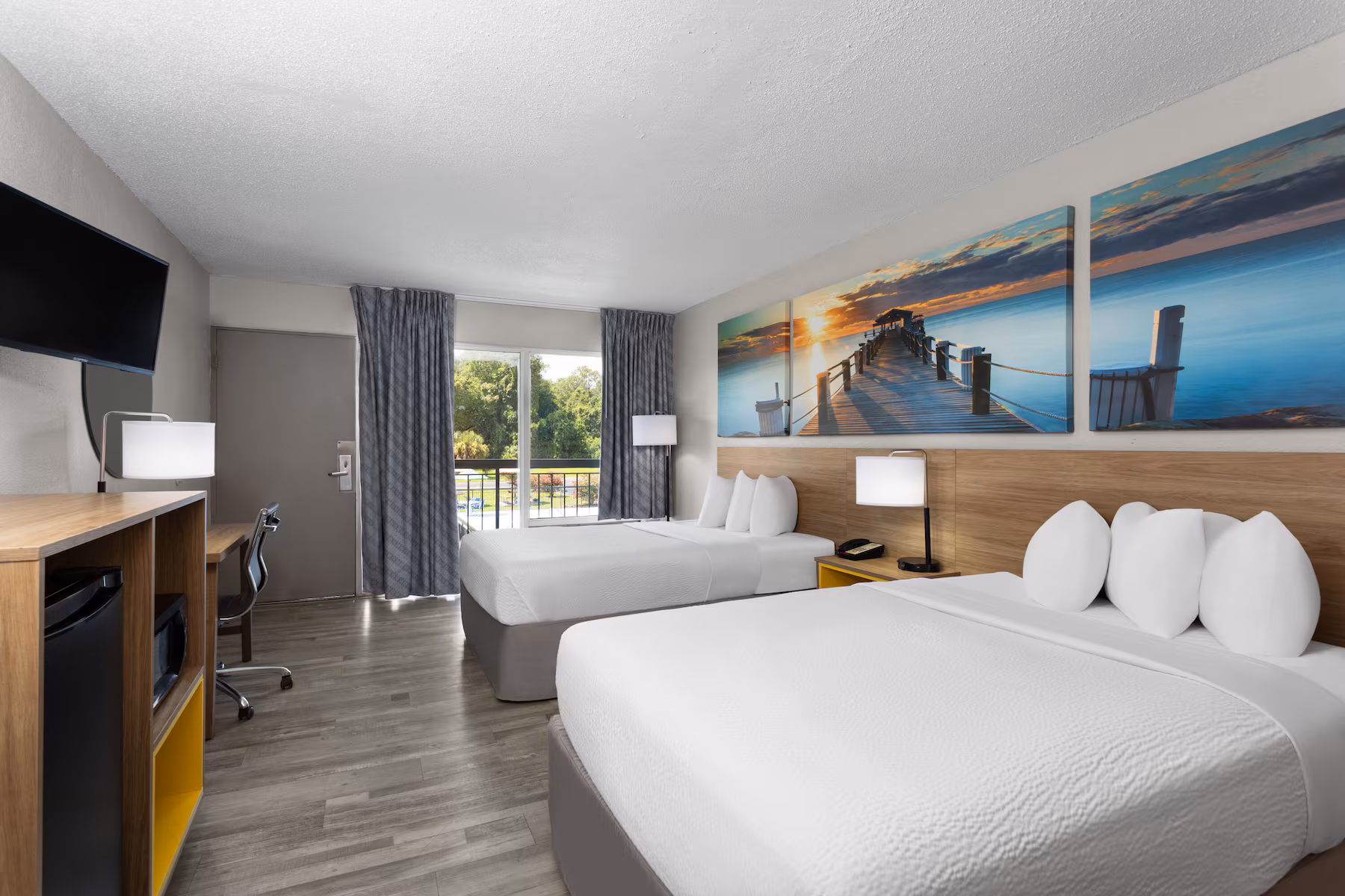 Guest room with two queen beds and balcony doors